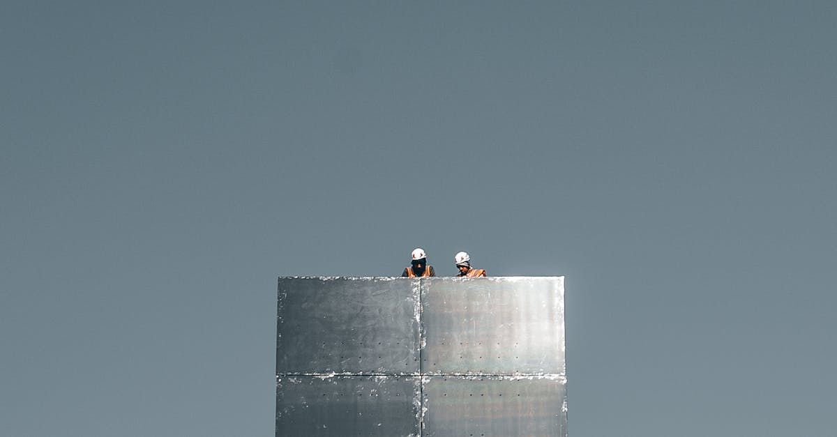Two men are standing on top of a large metal cylinder.