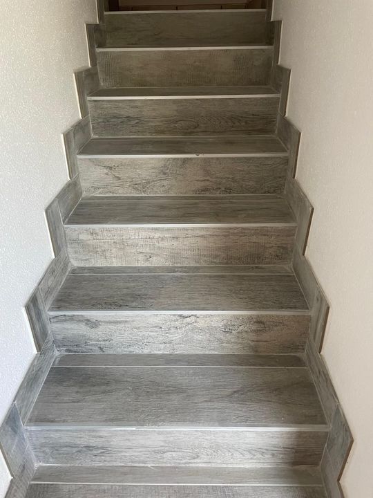 Scala interna stretta con gradini grigi e pareti bianche