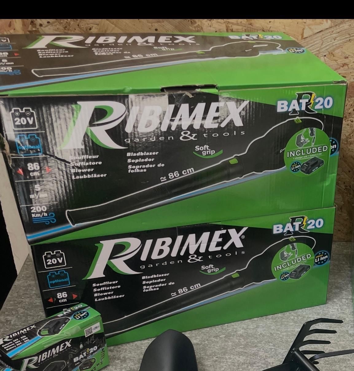 Due scatole Ribimex BAT20 verdi e nere sul pavimento, con un attrezzo abbinato visibile in un angolo.
