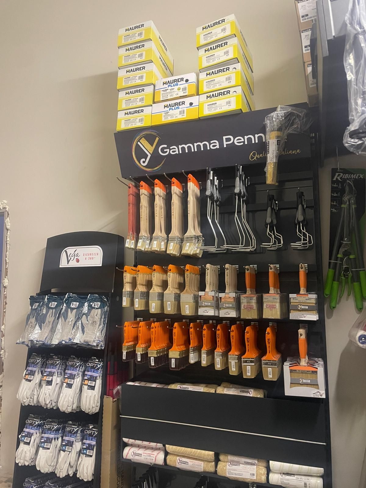 Scaffale espositivo Gunma Penn con articoli confezionati in arancione, nero e bianco in una corsia di un negozio.