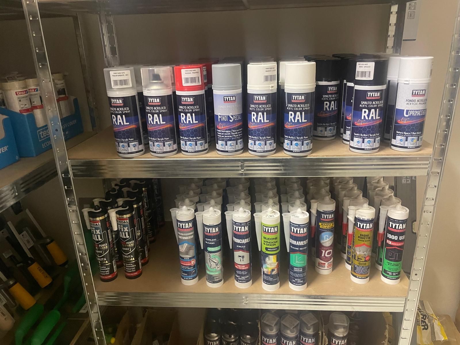 Scaffali pieni di bombolette spray di vari colori e marche