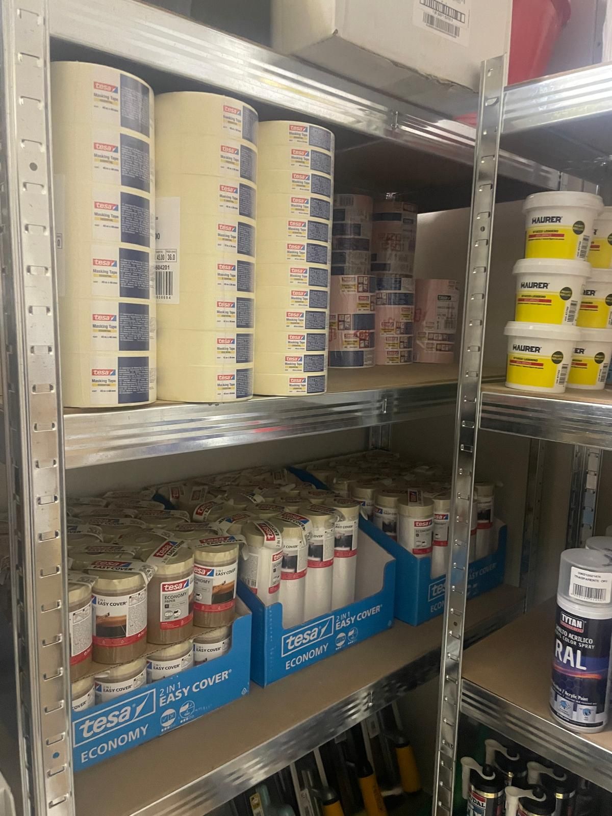 Scaffale del negozio pieno di lattine e bottiglie di prodotti per la casa o alimentari in una corsia