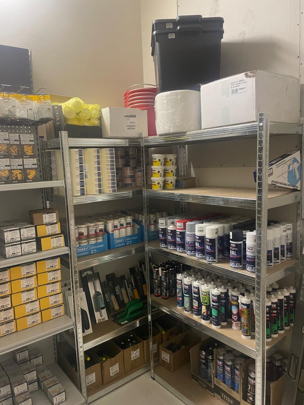 Scaffali pieni di conserve, scatole e provviste di vario genere in una dispensa o in un magazzino.