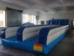 Blue and white inflatable obstacle course inside a building, likely for recreational use.