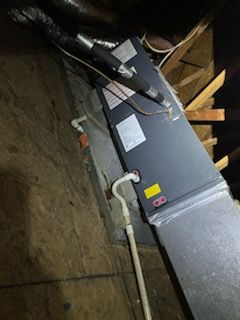 A water heater is sitting in the attic of a house.
