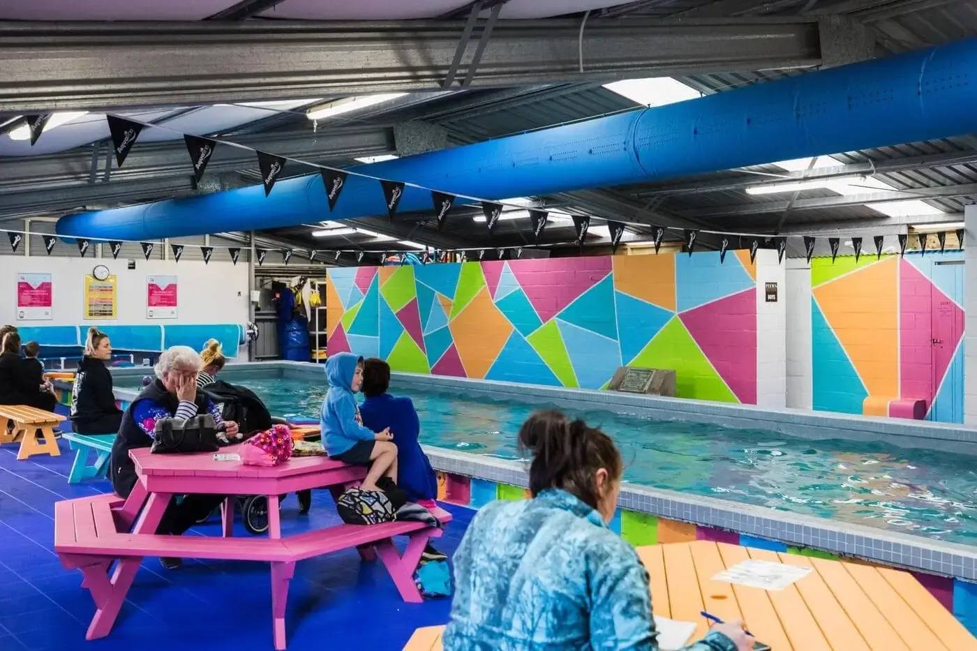 A woman is looking at a child in a swimming pool.