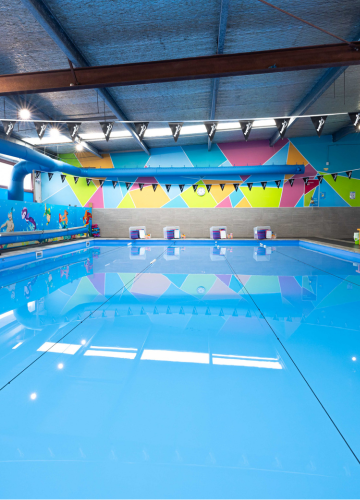 A woman is looking at a child in a swimming pool.