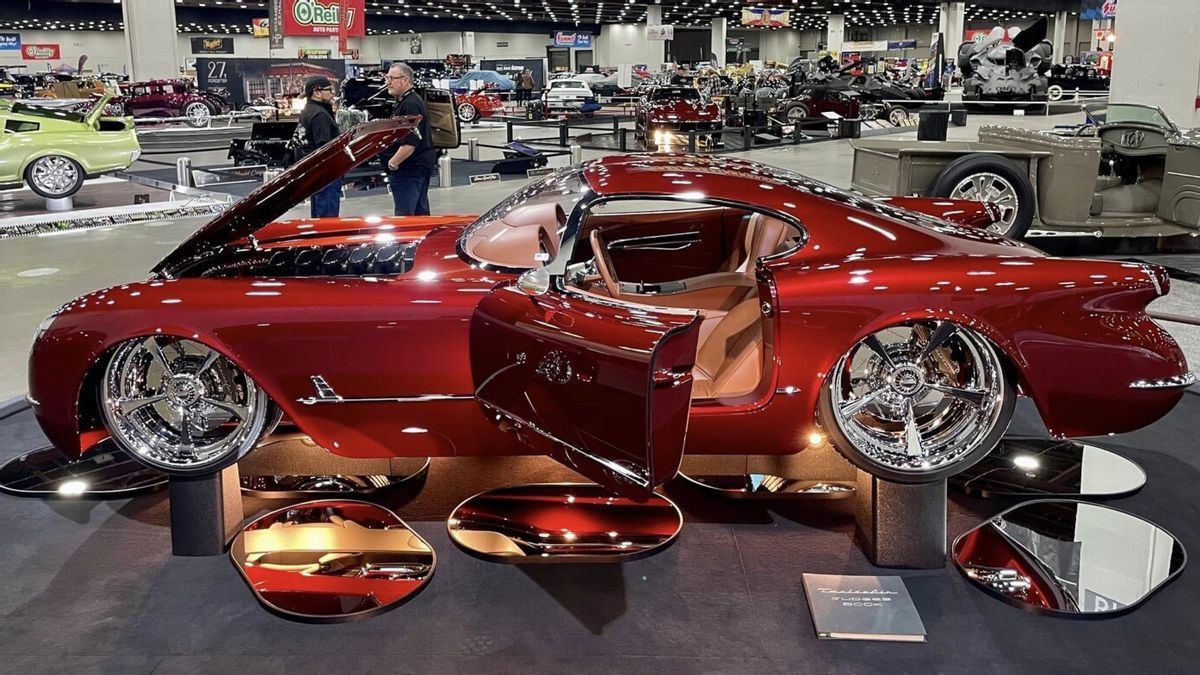 A red car with the door open is on display at a car show.