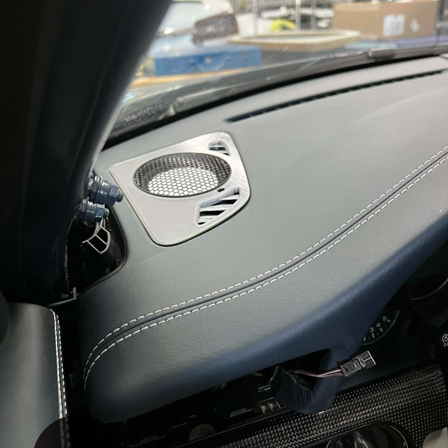 A close up of a car dashboard with a speaker on it.