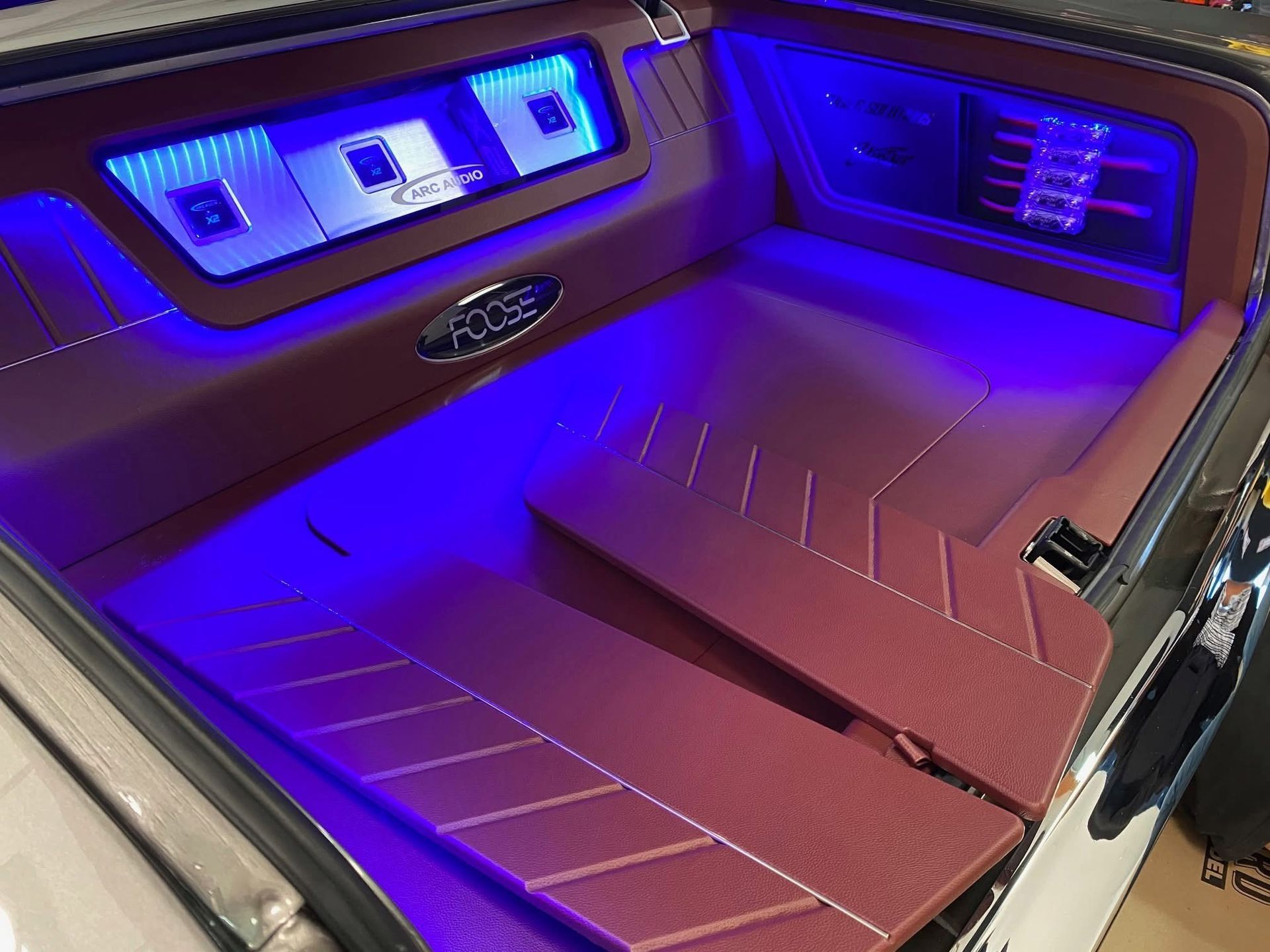 The trunk of a car with purple lights on it