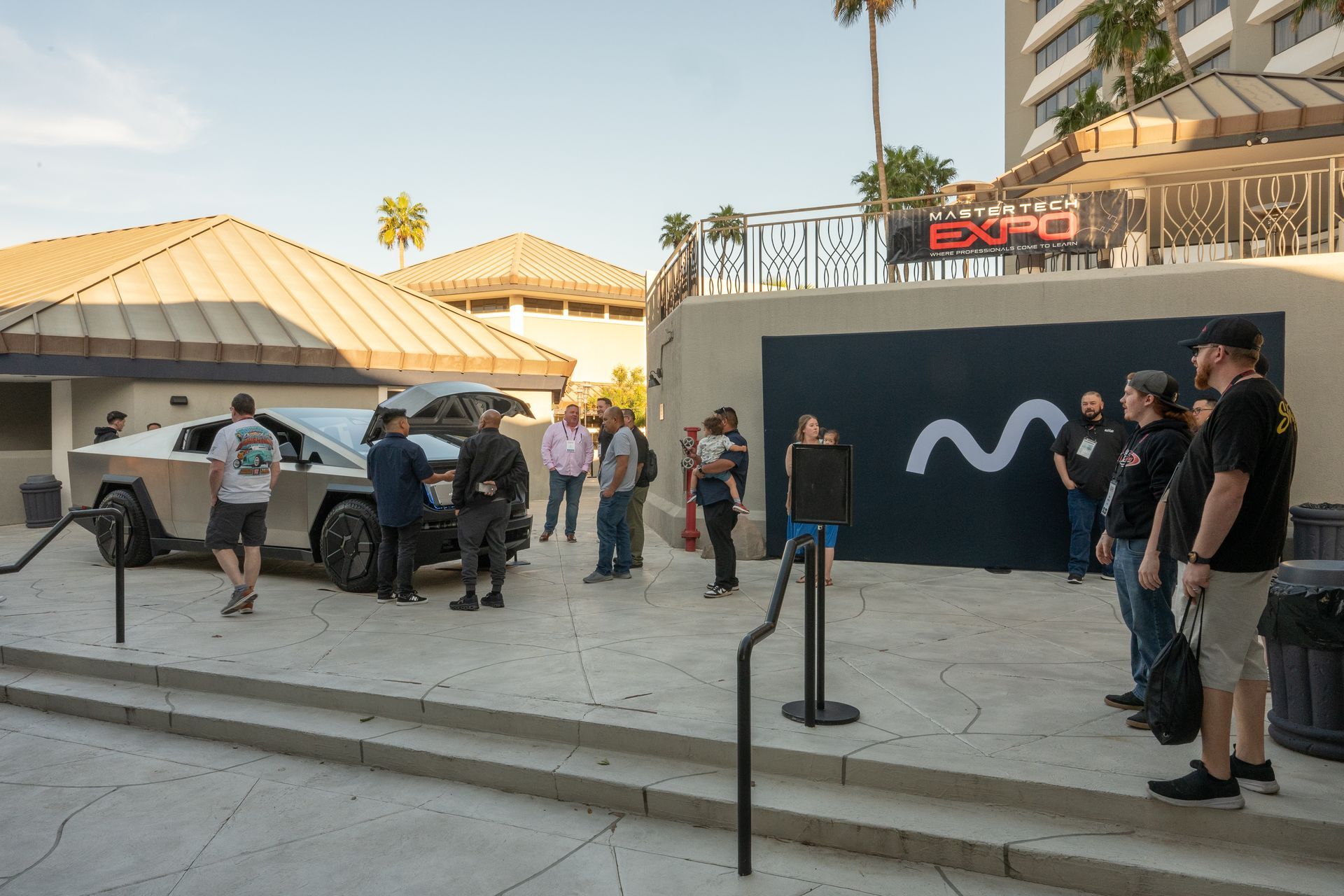 Cybertruck parked in front of an event with people gathered; building with 