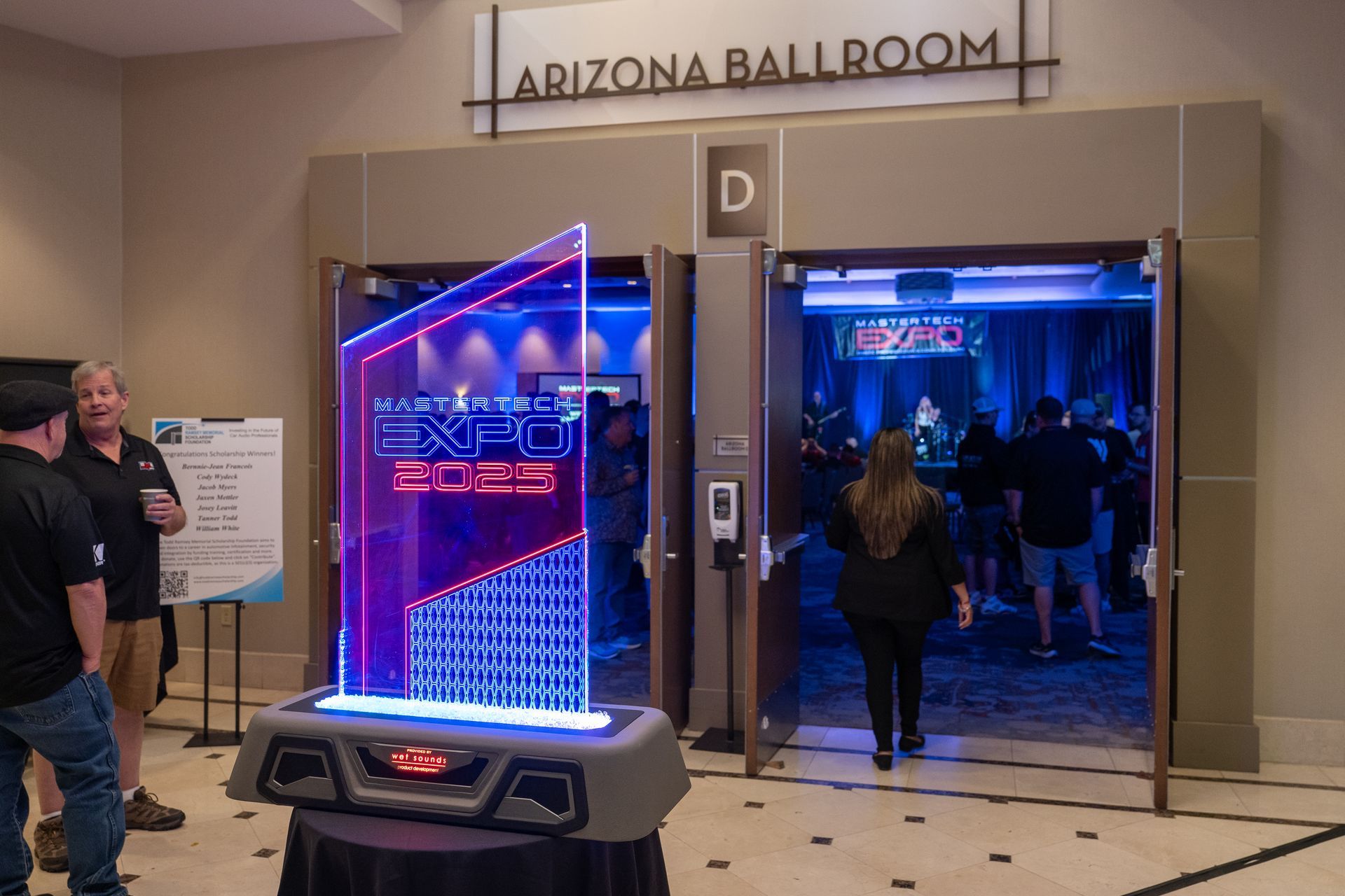 Entrance to the Arizona Ballroom at an expo, marked by a neon sign and people entering.