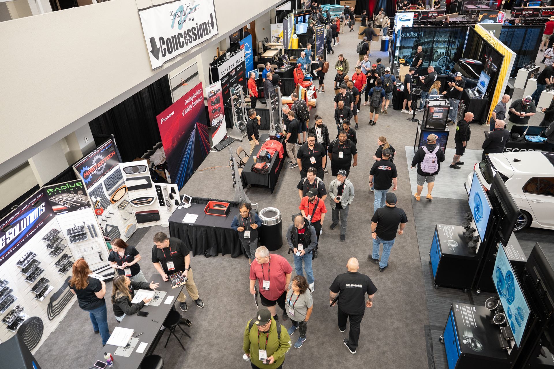 Overhead view of a crowded trade show floor with vendors and attendees.