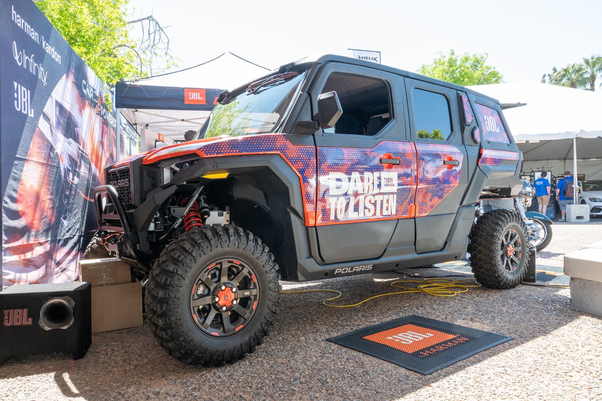 Off-road vehicle with JBL branding, orange and black accents, parked outdoors with 
