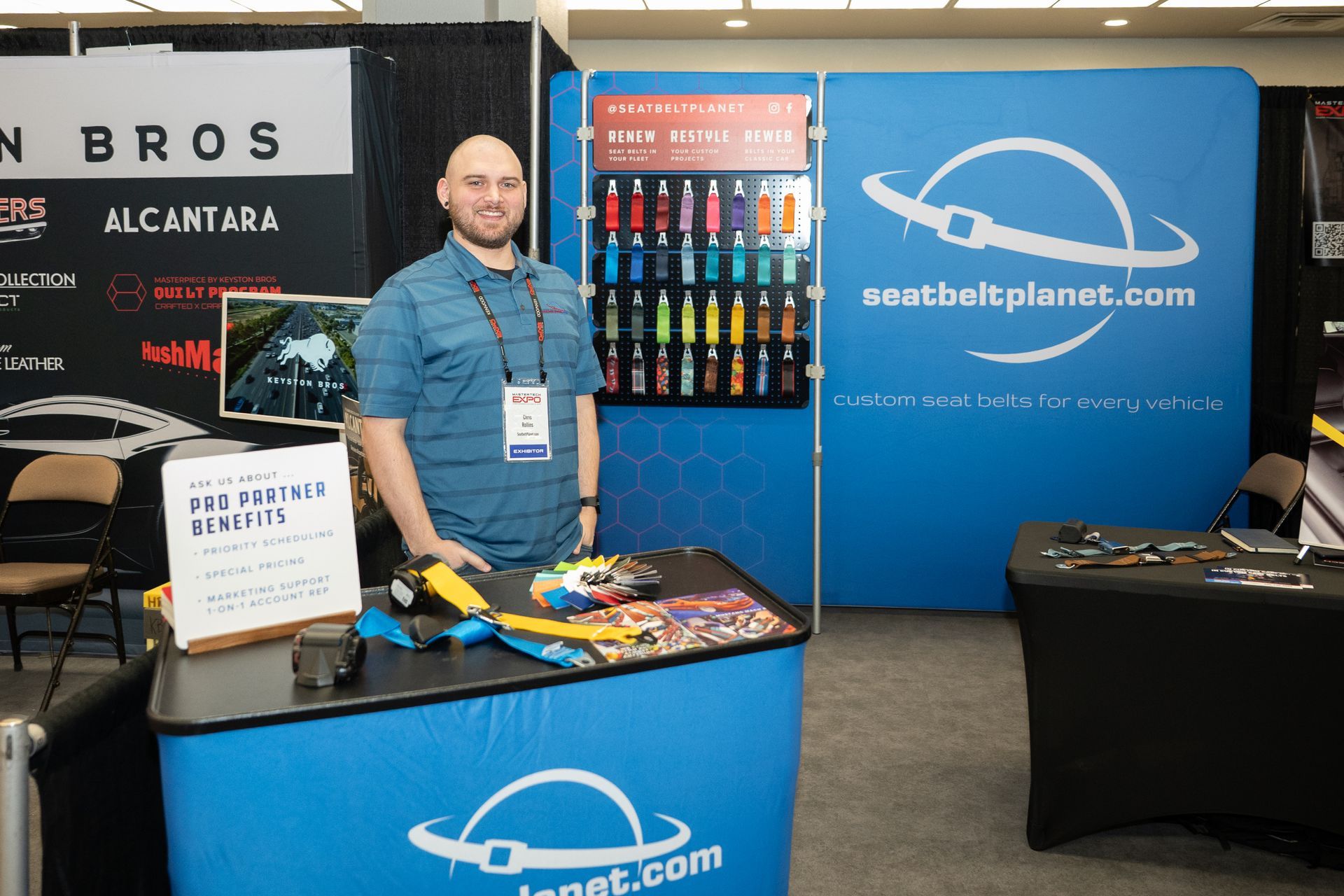 Man stands at a trade show booth promoting 