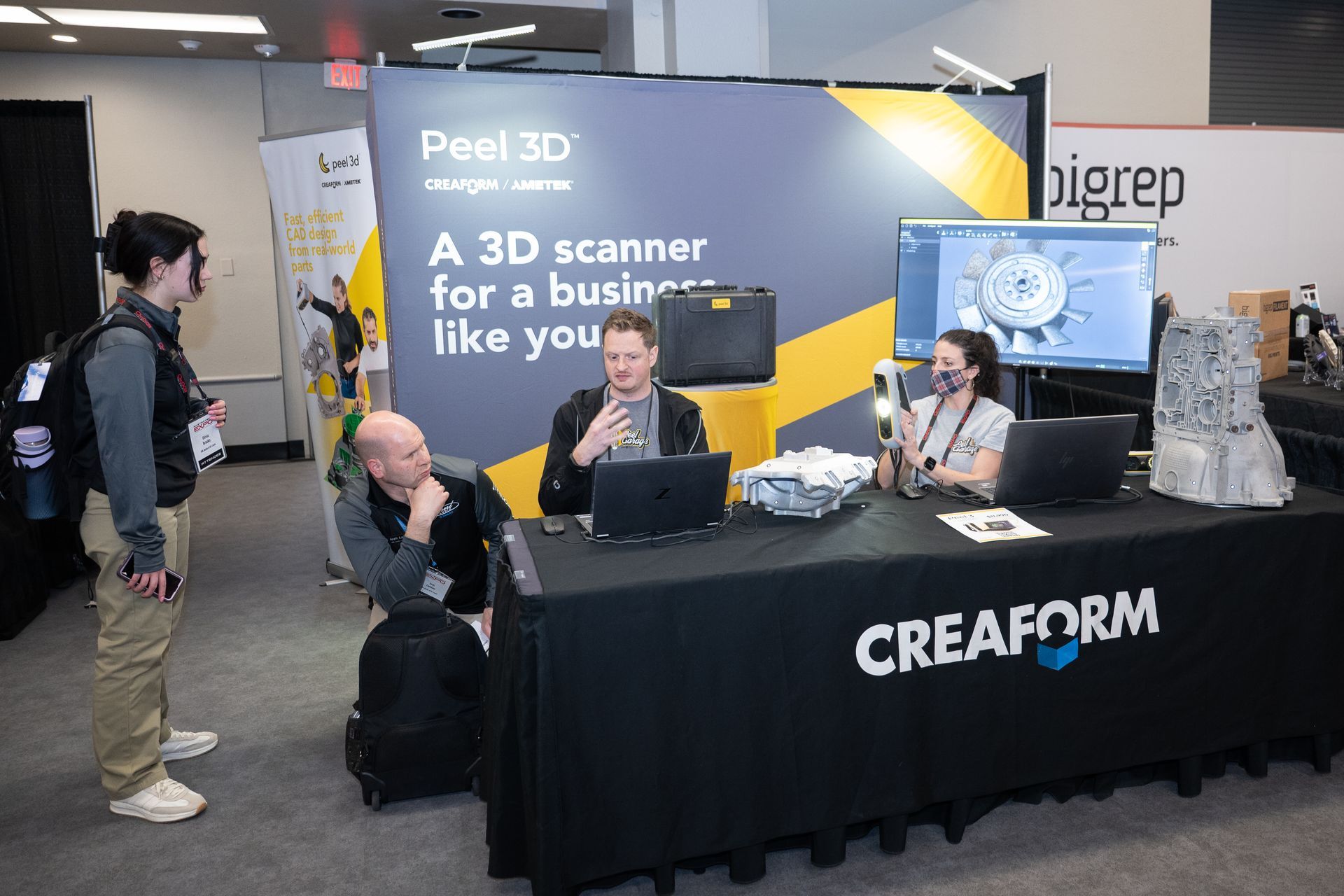 Trade show booth: Creaform display with three people, 3D scanner.