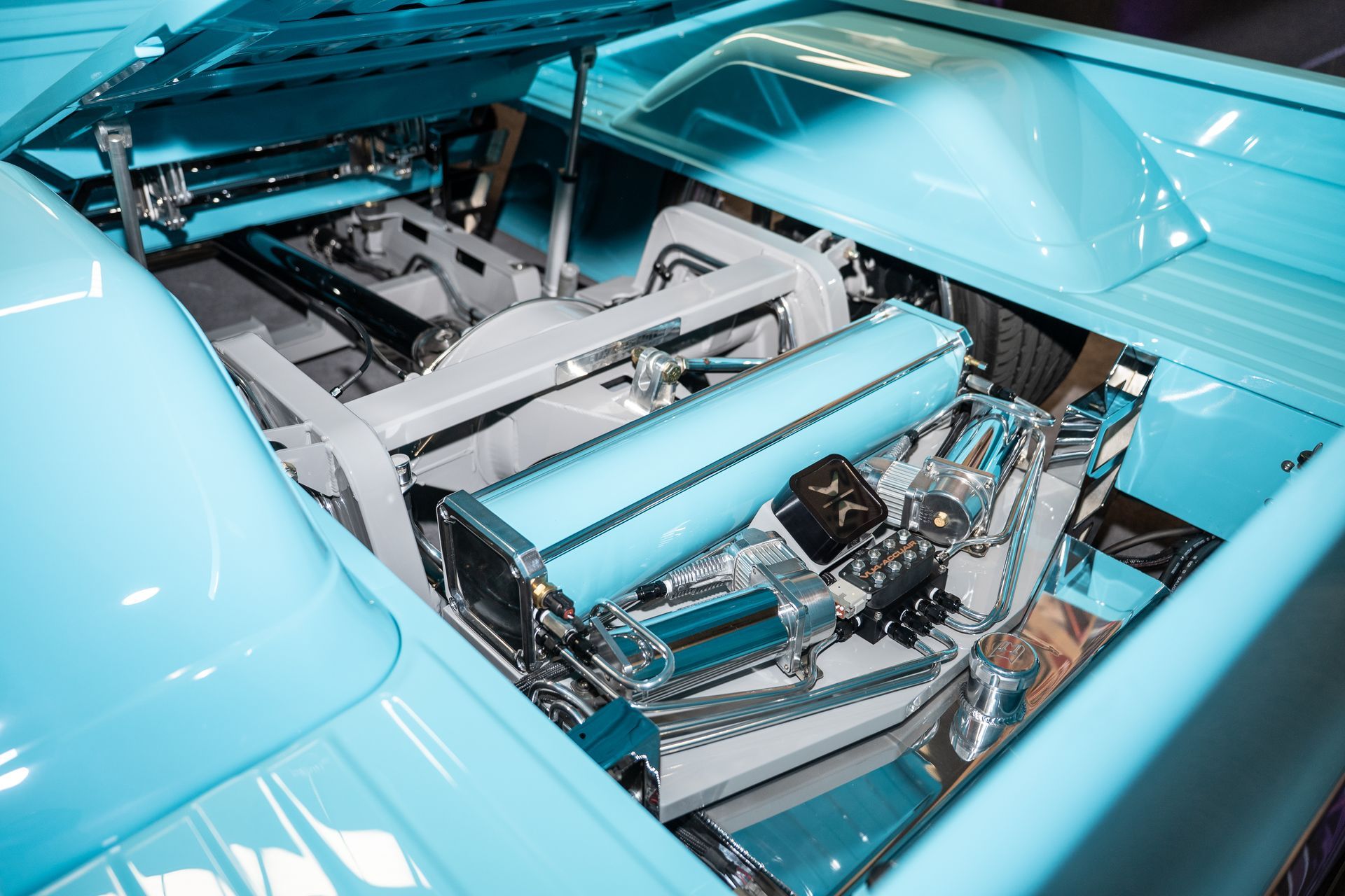 Teal-colored custom truck bed interior with detailed engine components.