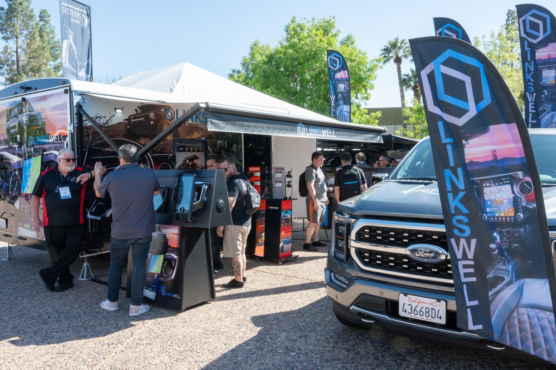 A booth with people gathered around a Ford truck. 