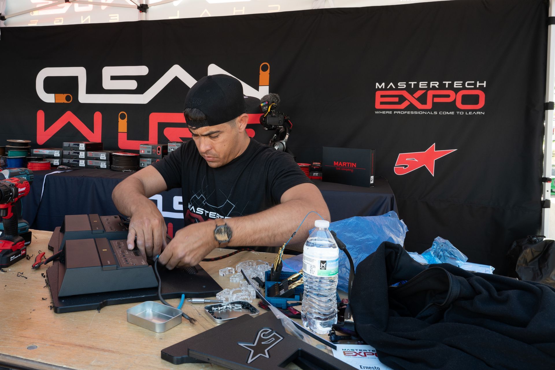 Man works on electronics at a booth with 