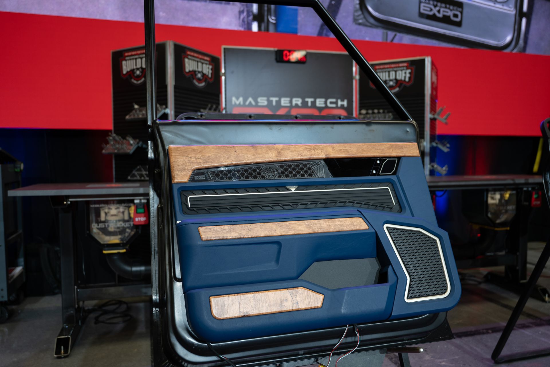 Custom car door panel, blue and wood grain accents. Black speaker grill and carbon fiber detail.