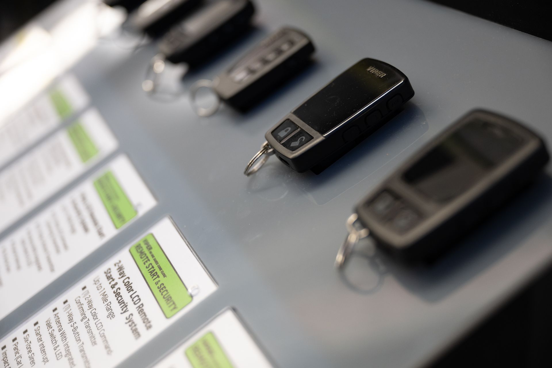 Key fobs lined up on a display, likely for a car security system, with product information.