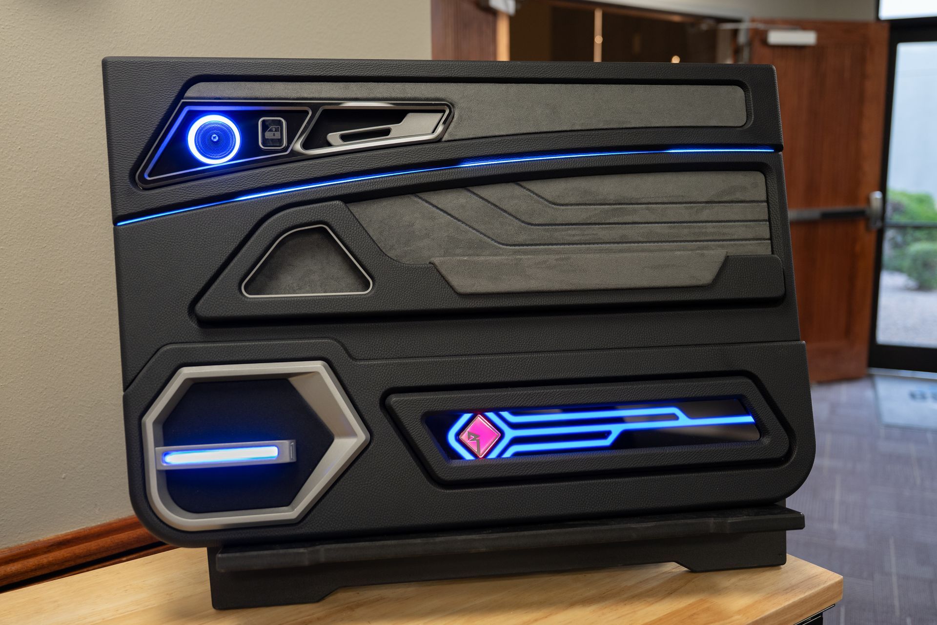 Custom black car door panel with blue LED lights.