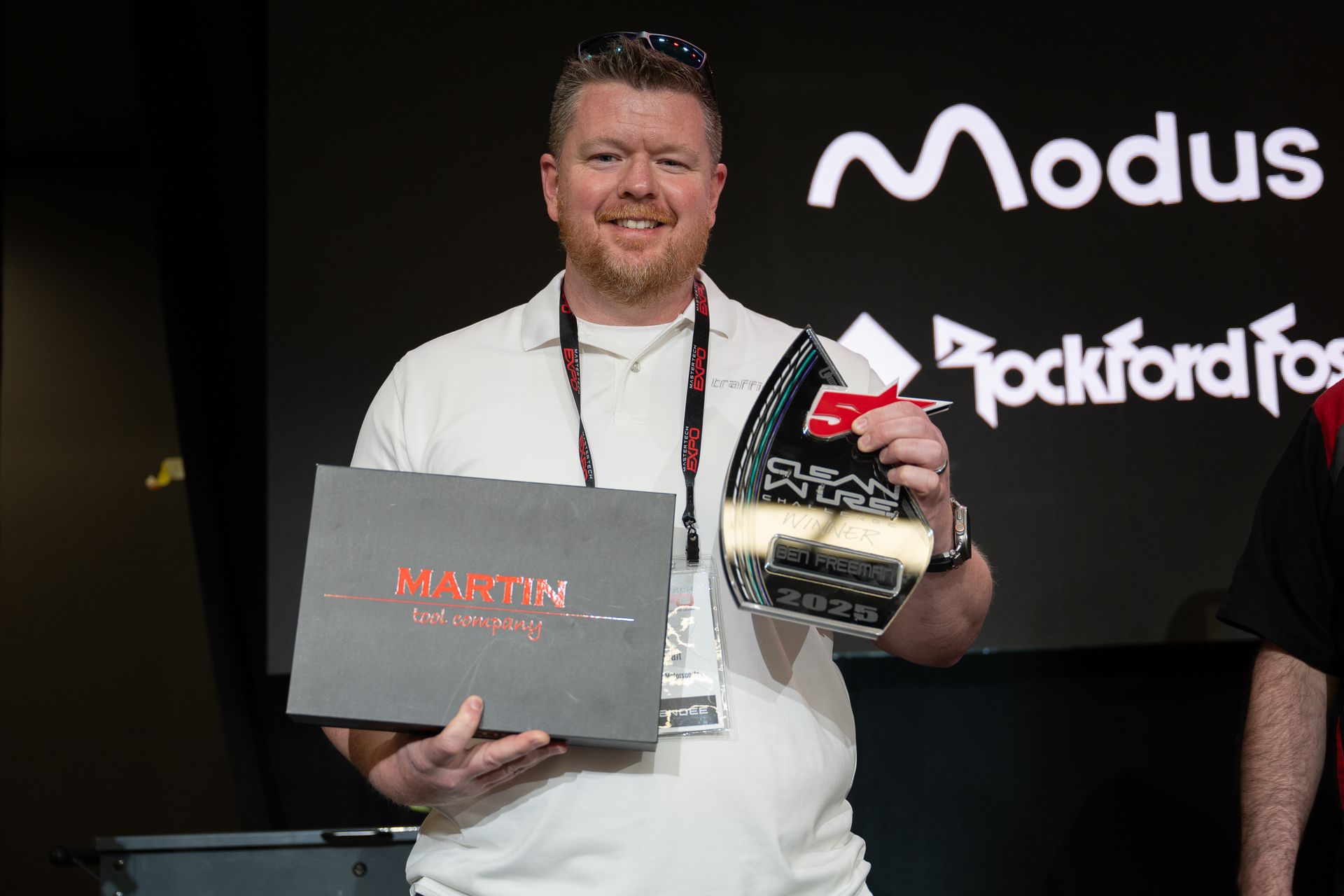 Man holding award and box, standing in front of 