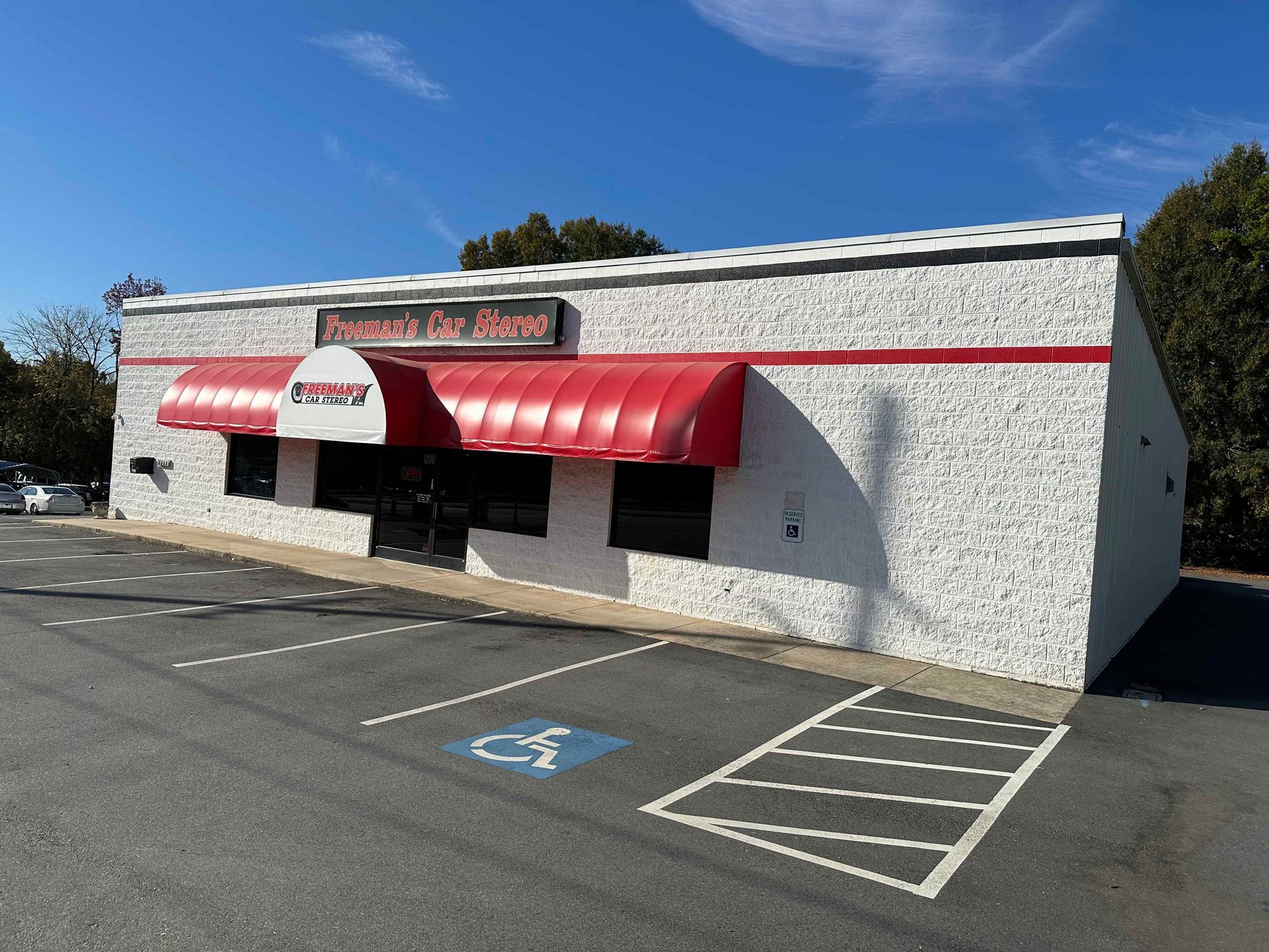 A white building with red awnings and a handicapped parking spot