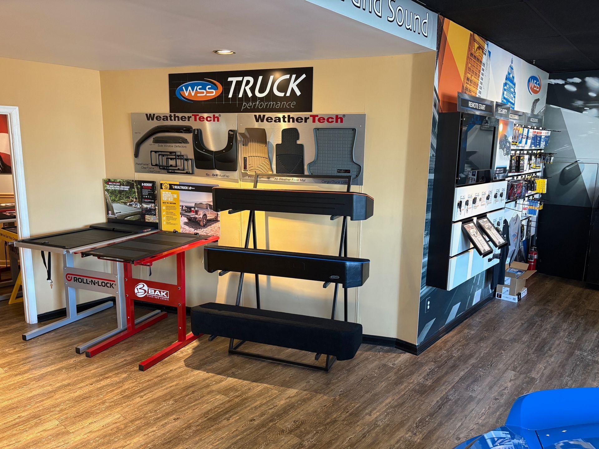 Interior of a truck accessory store with displays of floor mats, truck bed covers, and other items.