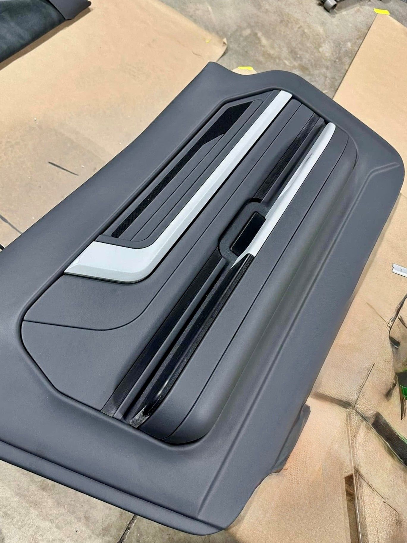 A black suitcase is sitting on top of a cardboard box.