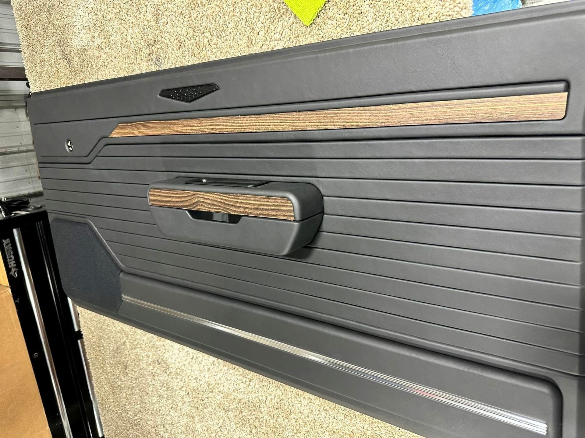 A close up of a door panel with a wooden handle.