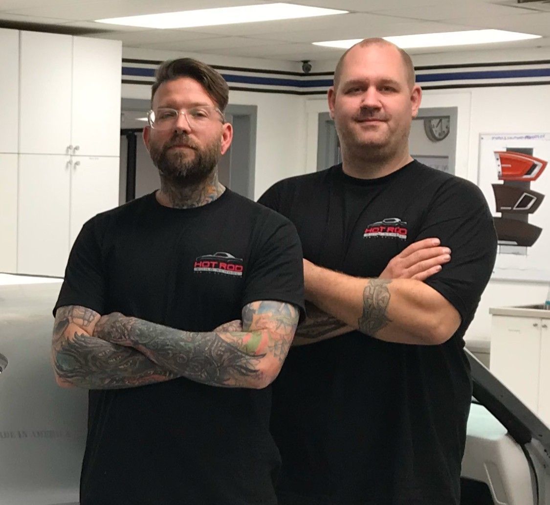 Two men standing next to each other with their arms crossed