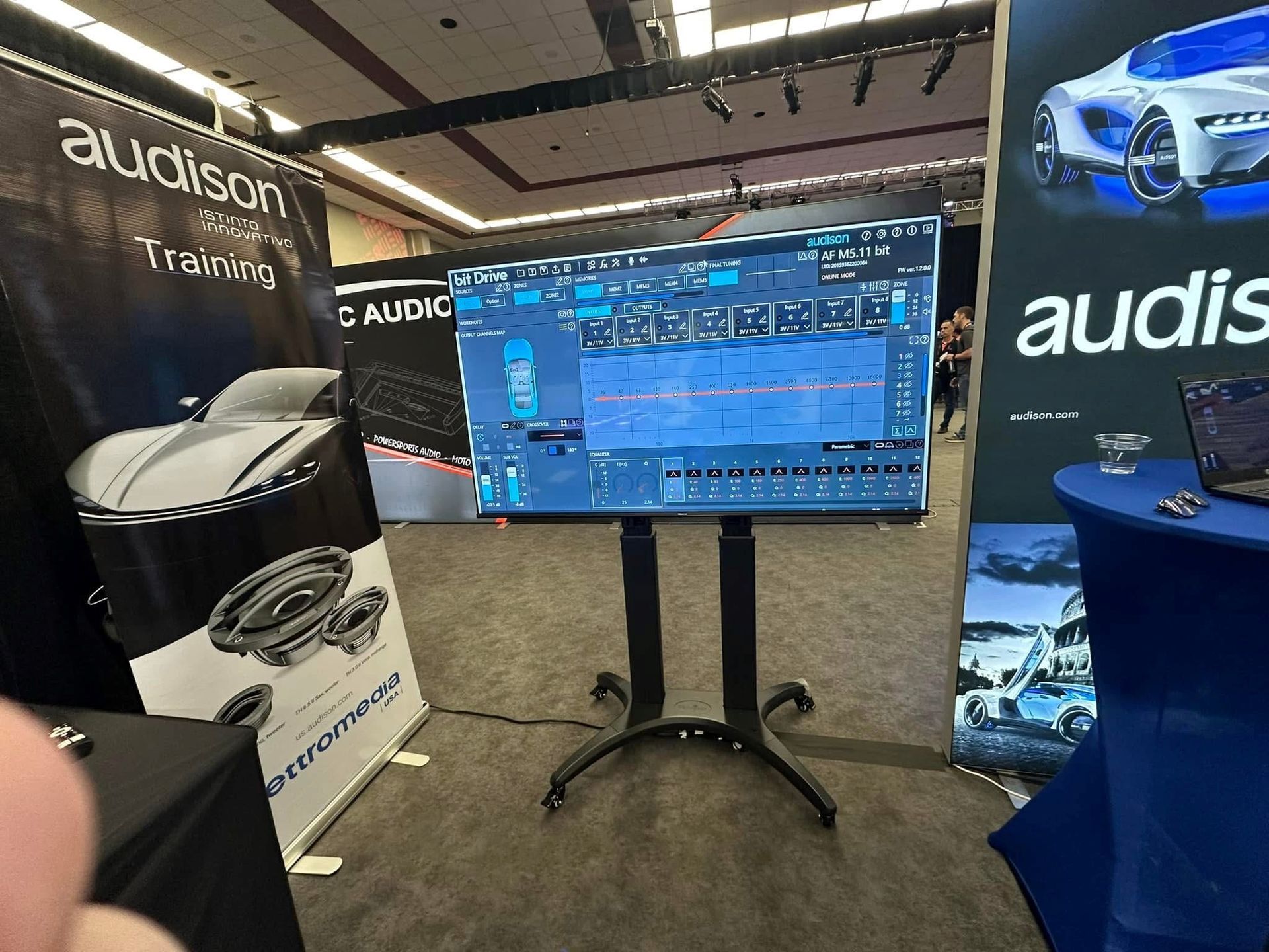 A tv on a stand in front of a sign that says audison