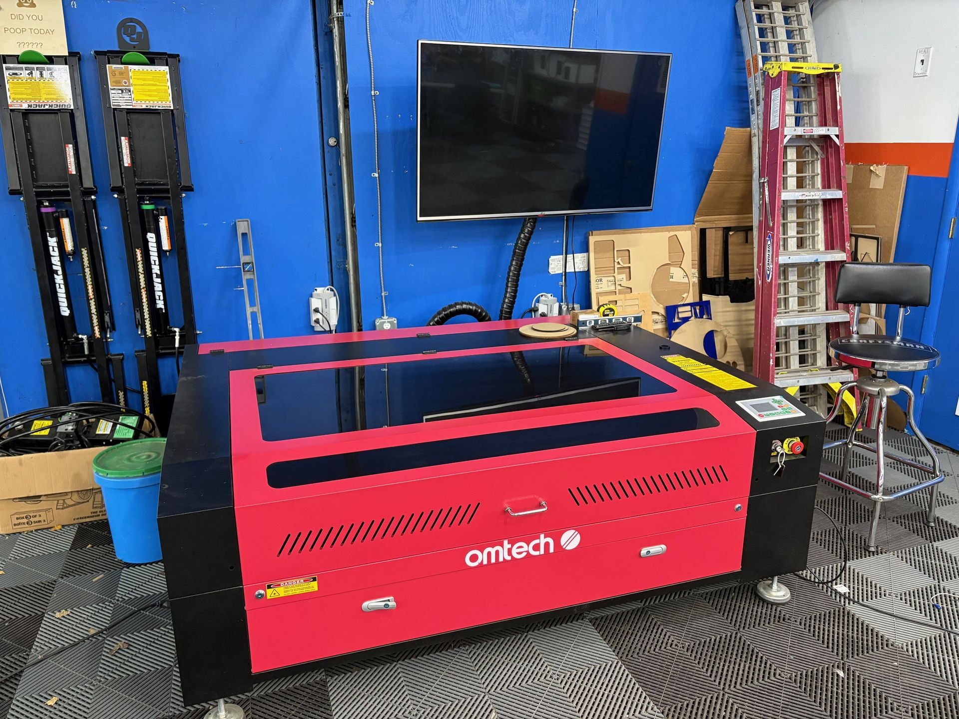 A red and black Laser cutting machine with the word omtech on it
