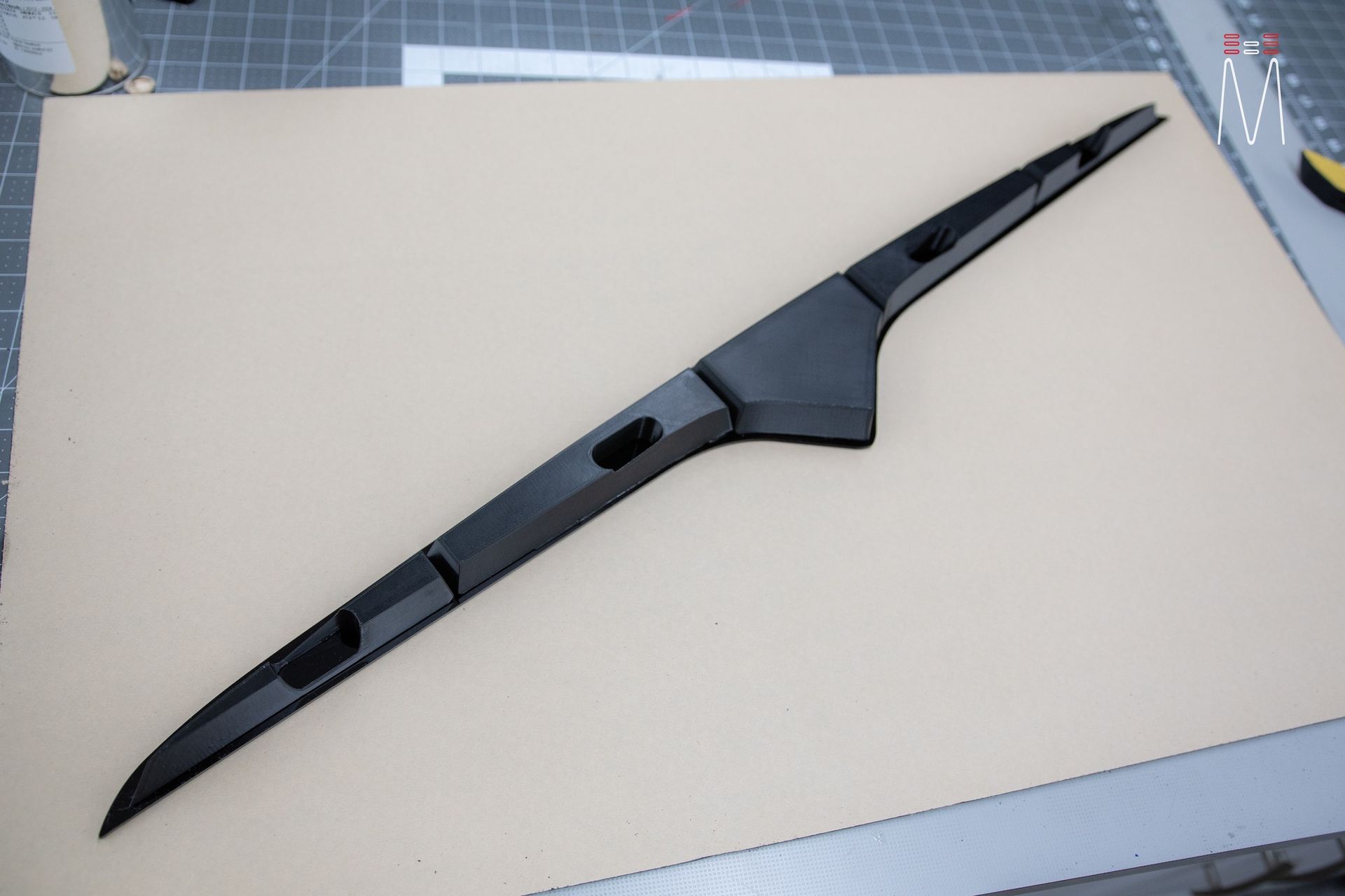 A black object is sitting on top of a piece of paper.