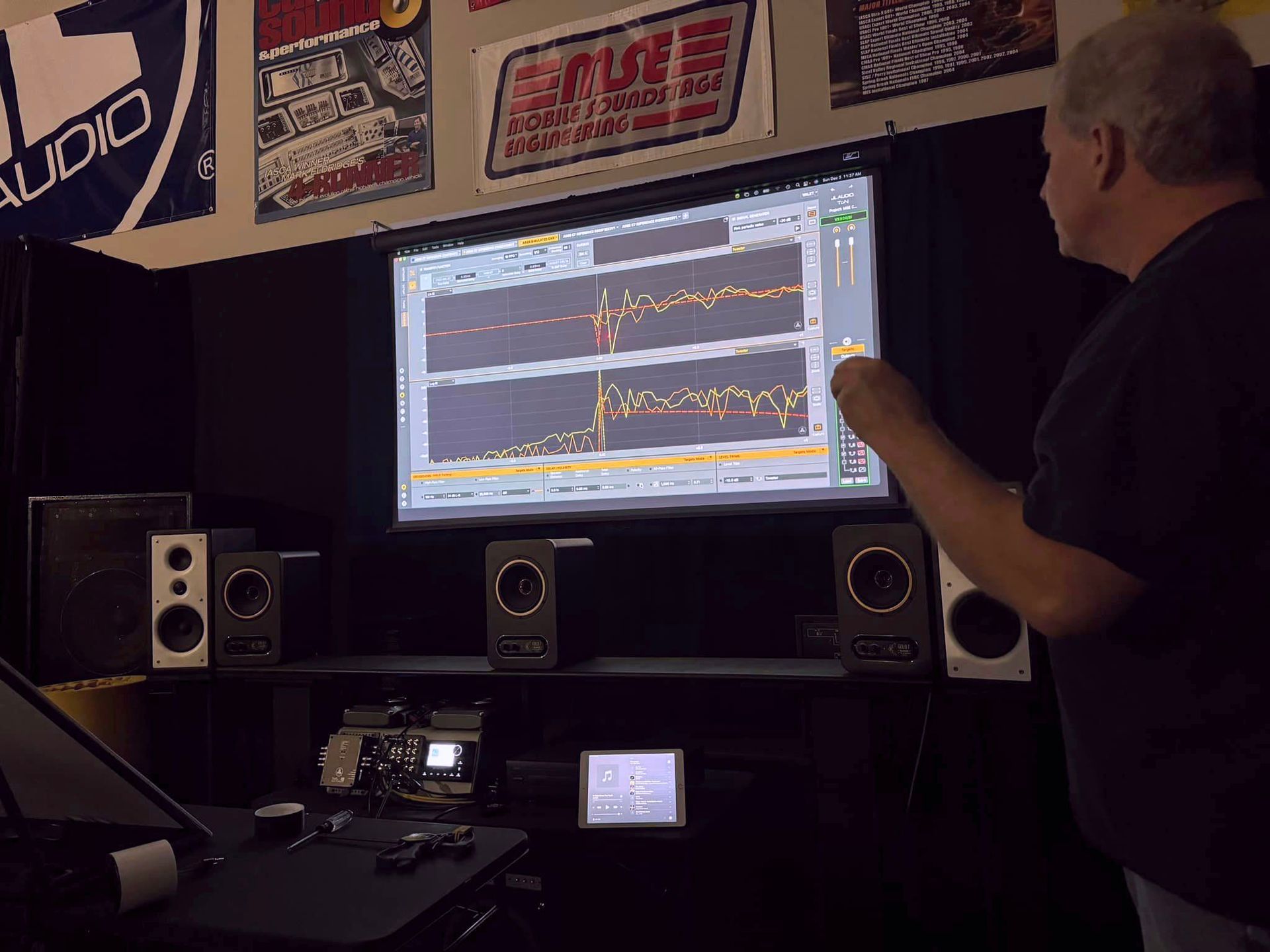 A man is standing in front of a screen that says rise on it