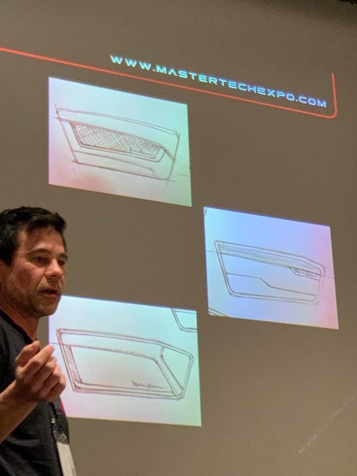 A man is giving a presentation in front of a projection screen.