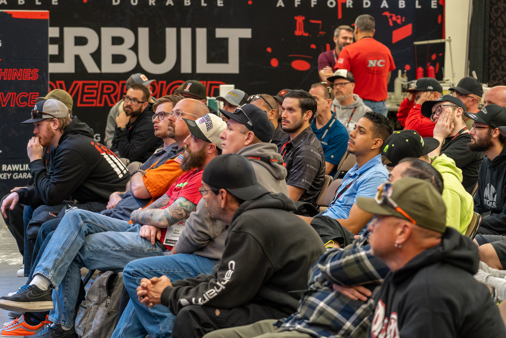 A group of men are sitting watching a competition.