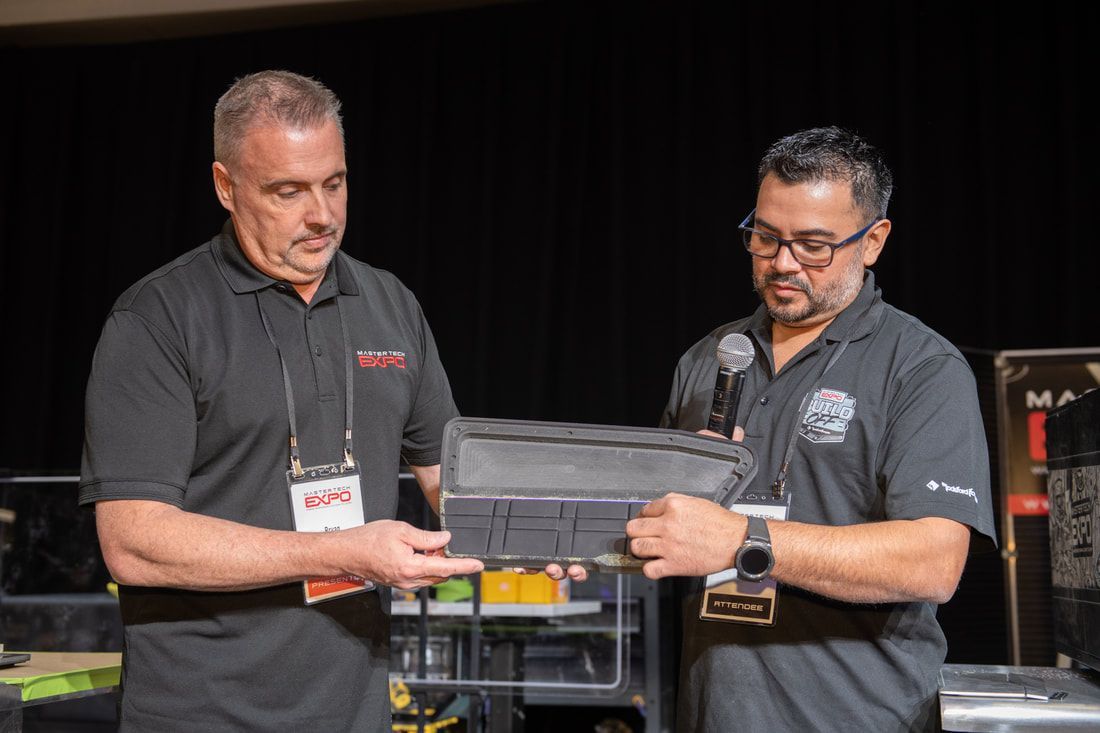 Two men are standing next to each other holding a piece of equipment.