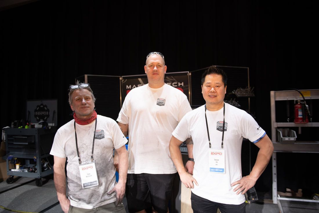 Three men are posing for a picture in a dark room.