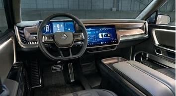 The interior of a car with a steering wheel and a large screen.