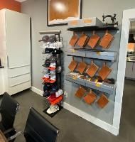 A room with a shelf full of hats and a chair.