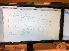 A computer monitor is sitting on a desk with a drawing on it.