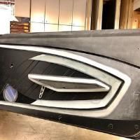 A close up of a bumper on a car in a garage.