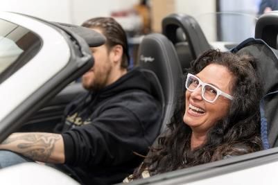 A man and a woman are sitting in a convertible sports car.