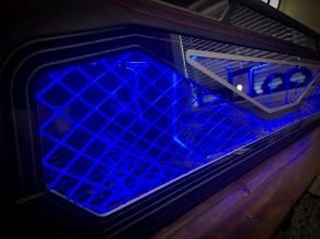 A blue light is shining on the side of a car.