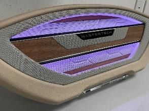 A close up of a speaker in a car with purple lights.