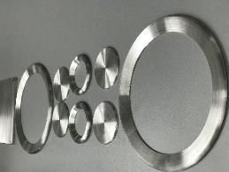 A group of stainless steel rings are sitting on top of each other on a table.