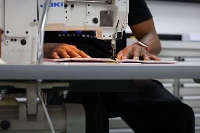 A man is using a sewing machine in a factory.