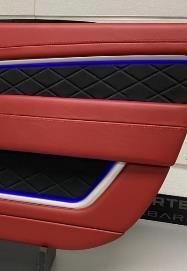 A close up of a red and black door panel on a car.